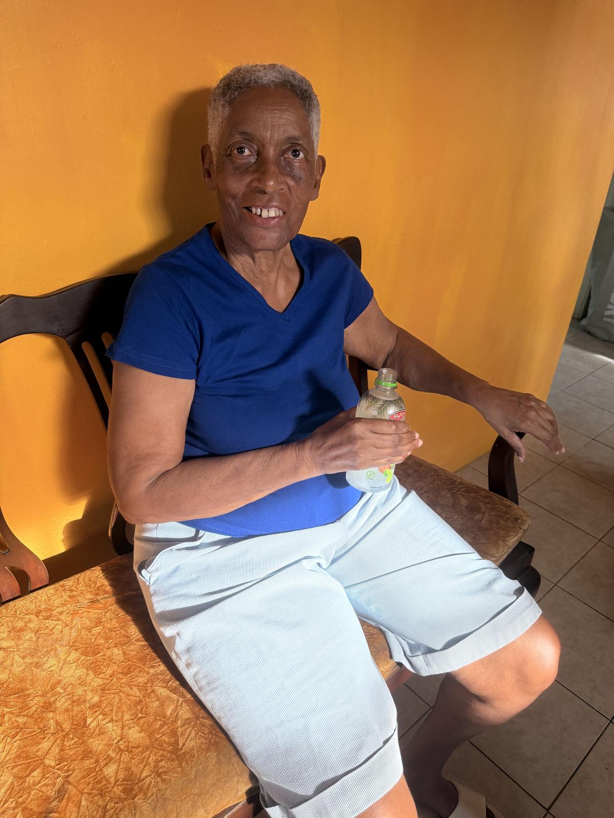 Monica smiling against a yellow wall